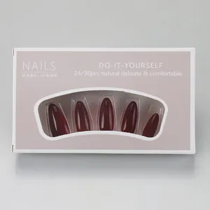 Detail view of glossy burgundy almond press-on nails in minimalist packaging box