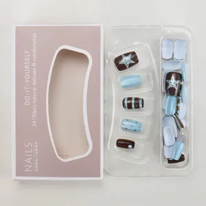 Flat lay of punk style brown and blue press-on nails with star patterns and stripes
