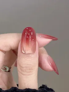 Macro view of glossy red-brown gradient ombre almond-shaped press-on nails
