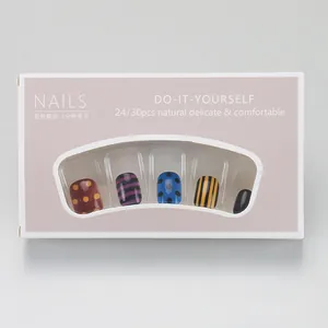 Detail view of pink packaging box for DIY nails featuring colorful dot and stripe patterns