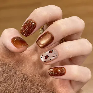 Unghie finte corte leopardate con effetto occhio di gatto e toni marroni ambrati chic