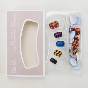Detail view of colorful checkered and polka dot press-on nail set in purple packaging