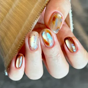 Uñas postizas cortas en ámbar marrón con textura jaspeada y diseños de lunares