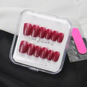 Glossy berry red short press-on nails set with box, file, and adhesive tabs in a tidy layout