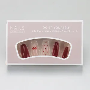Detailed view of red cat eye press-on nails with bow designs and polka dot accents