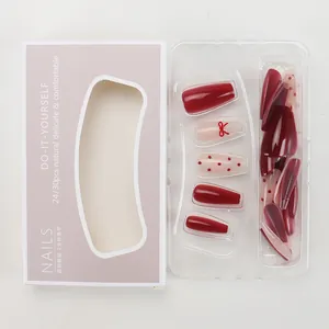 Detail of red cat eye press-on nails with 3D bow accent and polka dot pattern