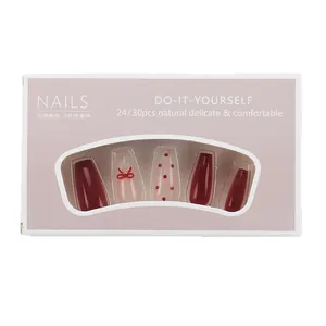 Press-on nail set with red gradient cat-eye design and 3D bow accents in pink packaging