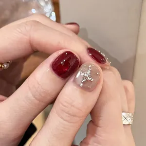 Elegant burgundy cat-eye press-on nails with pearl cross accents and nude base