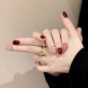 Press-on nails set with burgundy polish, plaid patterns and sparkling rhinestones