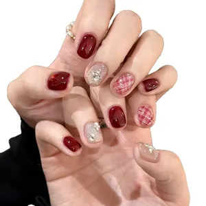 Short wine red cat-eye press-on nails with silver glitter and 3D rhinestones on white background