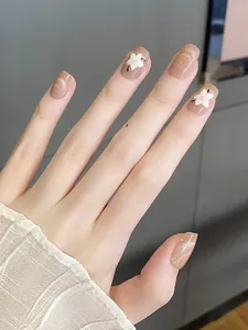 Detalle de uñas nude efecto ojo de gato con flores 3D blancas y elegante encaje lateral