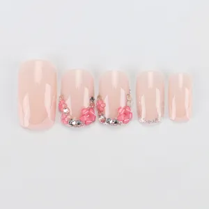 Unghie finte rosa con fiori 3D, strass e sfumatura glitter argento su sfondo bianco