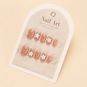 Uñas postizas artesanales cat-eye nude con diseños de flores 3D blancas en tarjeta