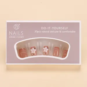 Detalle de uñas postizas rosa nude efecto ojo de gato con arte floral blanco en set