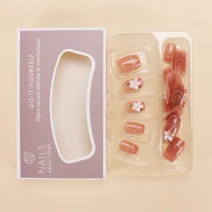 Detalle de uñas postizas ojo de gato rosa nude con flores 3D en caja de presentación