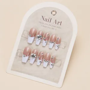 White French tip press-on nails with sparkling heart-shaped diamonds and medium coffin shape