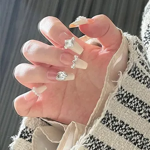 Close-up of pink gradient press-on nails with 3D pearls and sparkling zircon charms