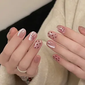 Faux ongles œil-de-chat rose clair avec pois rouges et motifs de nœuds faits à la main
