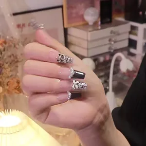 Handmade black press-on nails with metal butterfly ornaments and pearl accents