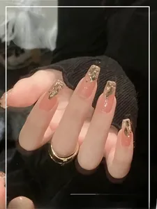 Detail of aurora champagne gold press-on nails with elegant gold foil on nude pink base