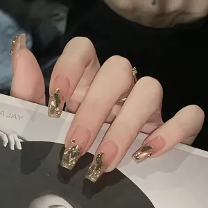 Long square press-on nails with nude pink base, gold foil accents and glitter details