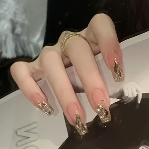 Close-up of long square press-on nails with champagne gold foil and glitter gradient