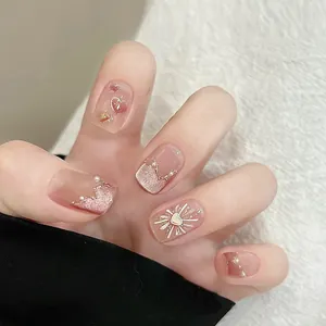 Dettaglio di unghie finte rosa con glitter cat-eye, perle 3D e decorazioni a cuore