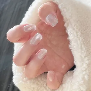 Close-up of square silver cat-eye press-on nails with white glitter and pearl finish