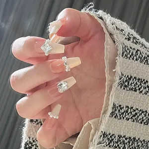 Macro detail of ballerina press-on nails with champagne gold gradient and luxury crystals