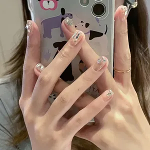 Detailed view of nude handmade press-on nails with silver glitter and sequins