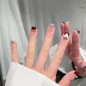 Detail of red and silver glitter press-on nails with 3D heart and star rhinestones