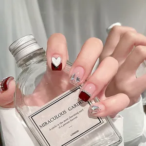 Deep red and nude press-on nails with silver heart rhinestones and glitter accents