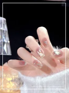 Detail of nude pink press-on nails with 3D bunny, pearls and silver swirl designs