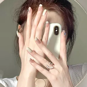Detailed view of mid-length cream French press-on nails with 3D bows and rhinestones