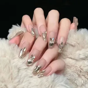 Short French white press-on nails with golden glitter, pearls, and metal rabbit charms