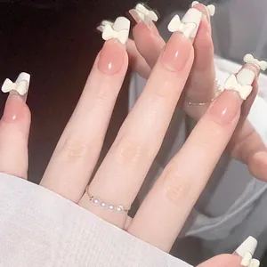 Medium long trapezoid press-on nails with white French tips and 3D bow accents