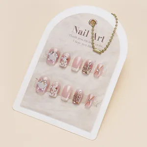 Short square press-on nails with pink rabbit designs, pearls and glitter accents