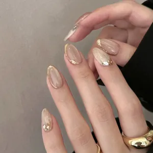 Short oval nude press-on nails with golden metallic edges and tiny rhinestones decor