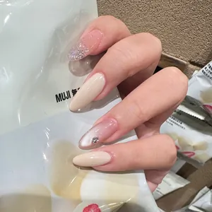 Almond nude press-on nails with silver glitter gradient and a rhinestone accent