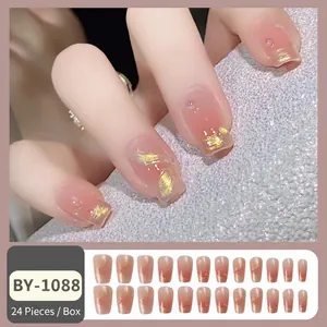 French ballerina press-on nails with nude pink gradient, gold foil, and rhinestones