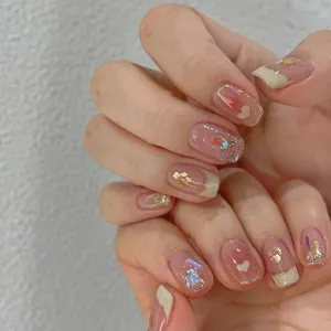 Detailansicht handgefertigter Klebenägel mit Herzmustern, Goldfolie und Aurora-Pailletten