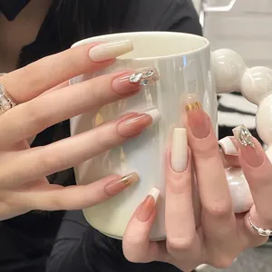 Lange Sarg-Kunstnägel mit weißen French-Tips, Nude-Verlauf und luxuriösen Strasssteinen