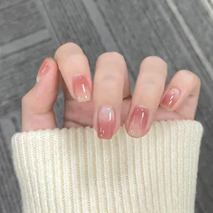 Close-up of short square-oval press-on nails with pink gradient and mirror finish