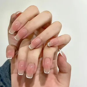 Close-up of French ombre short square press-on nails in nude pink and white