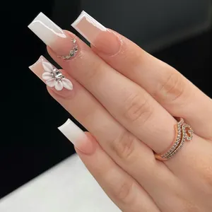 Unghie lunghe quadrate con sfumatura marrone, fiori 3D e strass su mani femminili