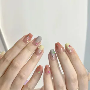 Detailed view of short French ombré press-on nails with stars and rhinestone accents