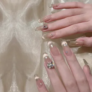 Cat-eye press-on nails in nude pink with rhinestones and heart crystals on gold silk