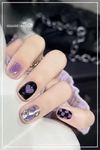 Detailed view of handmade purple and black heart checkered nails with crystal rhinestones