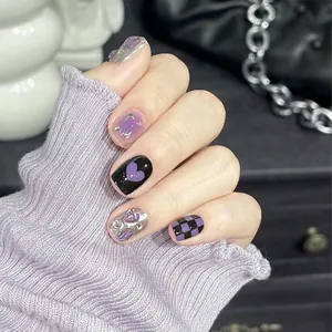 Detail of purple and black press-on nails with 3D bows and aurora heart designs