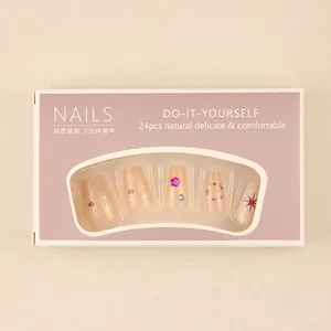 Detail of 24pcs nude pink press-on nails set with heart and star patterns in packaging